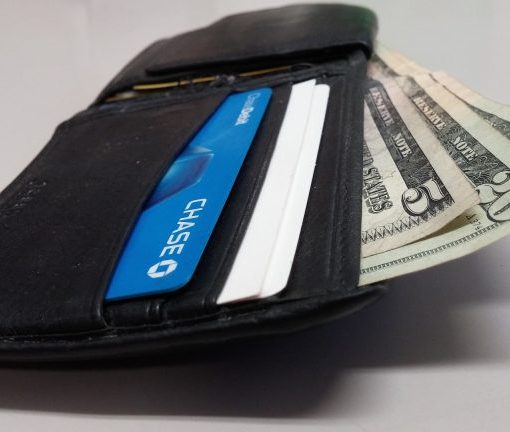 Open wallet with cash and credit card, symbolizing personal finance and spending habits.