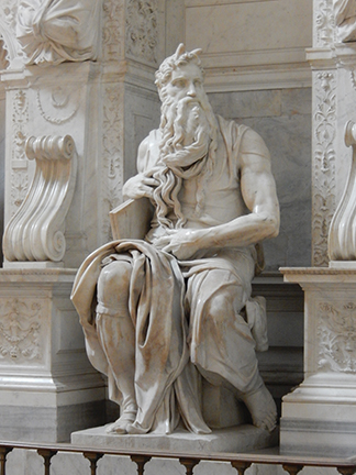 Intricately carved marble statue of a seated historical figure with a flowing beard, holding a tablet, surrounded by ornate details.