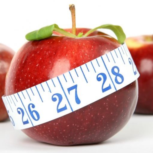 Red apple with measuring tape symbolizes healthy diet and weight loss.